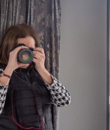 An image of the photographer Paula Nolan, from behind her camera. Waterford city can be seen from the window