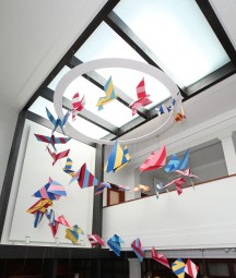 image of brightly coloured floating sculpture with origami style birds flying in an upwards spiral