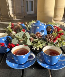 Blue tea set with white polka dots surround by a Christmas wreath