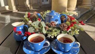 Blue tea set with white polka dots surround by a Christmas wreath