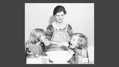 Image of a mother and her two children baking