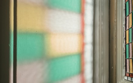 Light coloured by a stained glass window refracted on a wall in the NLI's Main Library Building