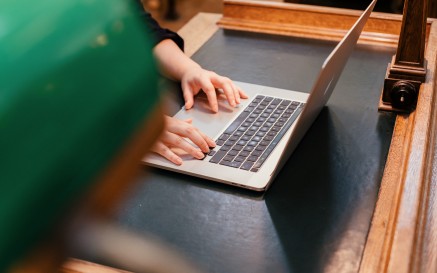 Person's hands typed on a computer keyboard