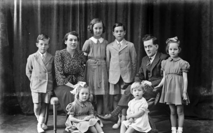 Black and white photograph depicting a family group with several children