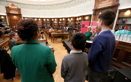 The backs of three children participating in Poetry Aloud 2023