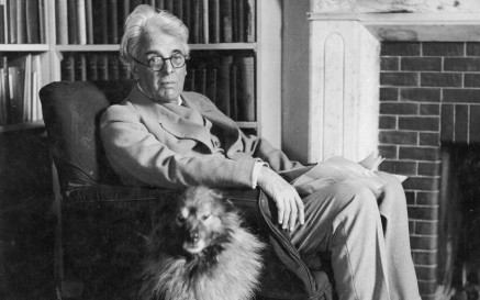 Yeats sitting in armchair with his dog