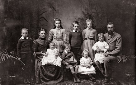 Black and while photograph of a group of adults and children.