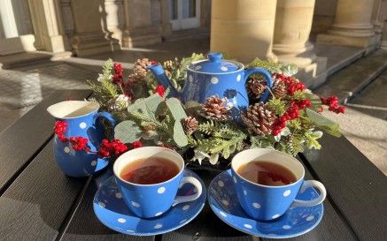 Blue tea set with white polka dots surround by a Christmas wreath